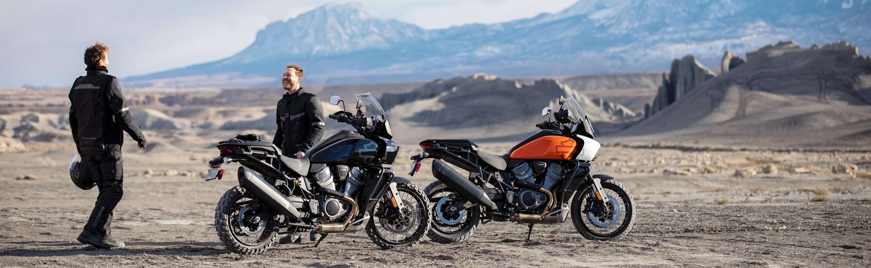 Riders standing next to two 2024 Harley-Davidson Pan America 1250 Special motorcycles.